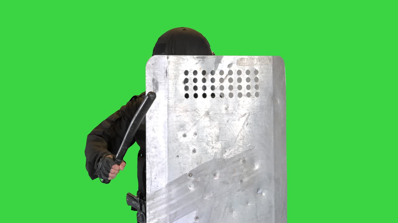 Polizia antisommossa che avanza con scudo e manganello alzati su Green Screen, Chroma Key