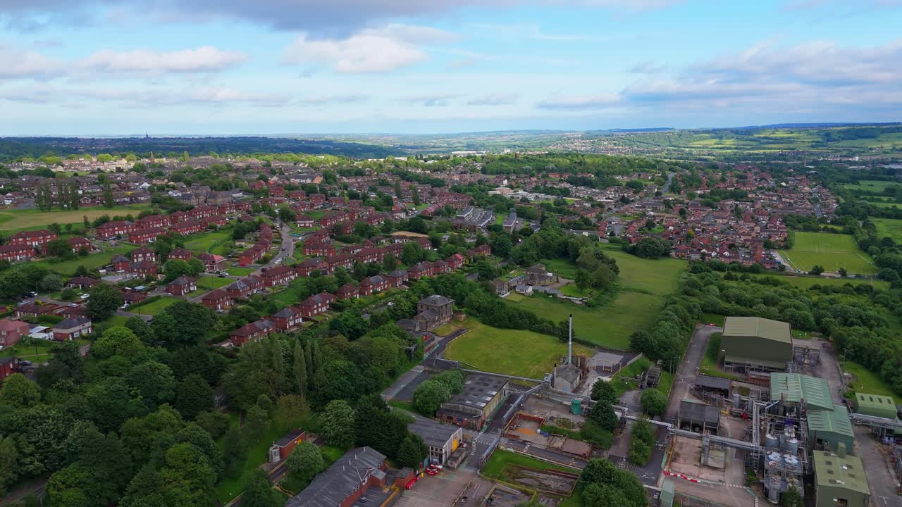 Aerial View of a Town with Residential Houses, Green Spaces, and Industrial Buildings