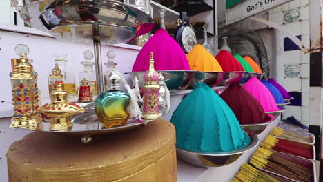 Street-side-store-in-Kerala,-India-selling-perfumes,-incense,-and-colorful-dyes