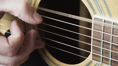 close-up of a person playing acoustic guitar