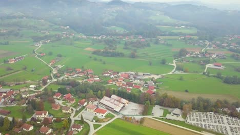 A-smooth-slow-drone-moving-over-the-rich-green-and-colorful-view-of-an-mesmerizing-valley-with-a-beautiful-developed-village-covered-with-lush-green-mountains