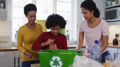 Mixed-race-lesbian-couple-and-daughter-cleaning-kitchen