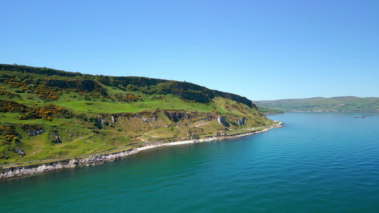 Aerial video of the Causeway Coastal Route at Glenarm in County Antrim, Northern Ireland, UK on a bright and sunny day. Filmed in 4K, 60FPS and with Rec709 color.