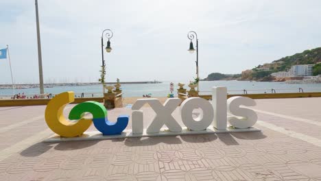 Sant Feliu de Gu&iacute;xols on the Costa Brava of Gerona Spain tourist town sign closeup with beach background