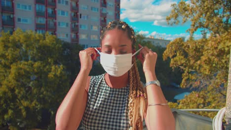 Portrait-of-Young-Mixed-Race-Woman-Taking-Off-Face-Mask-With-Smile