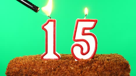 cake with the number 15 lighted candle. chroma key. green screen. isolated