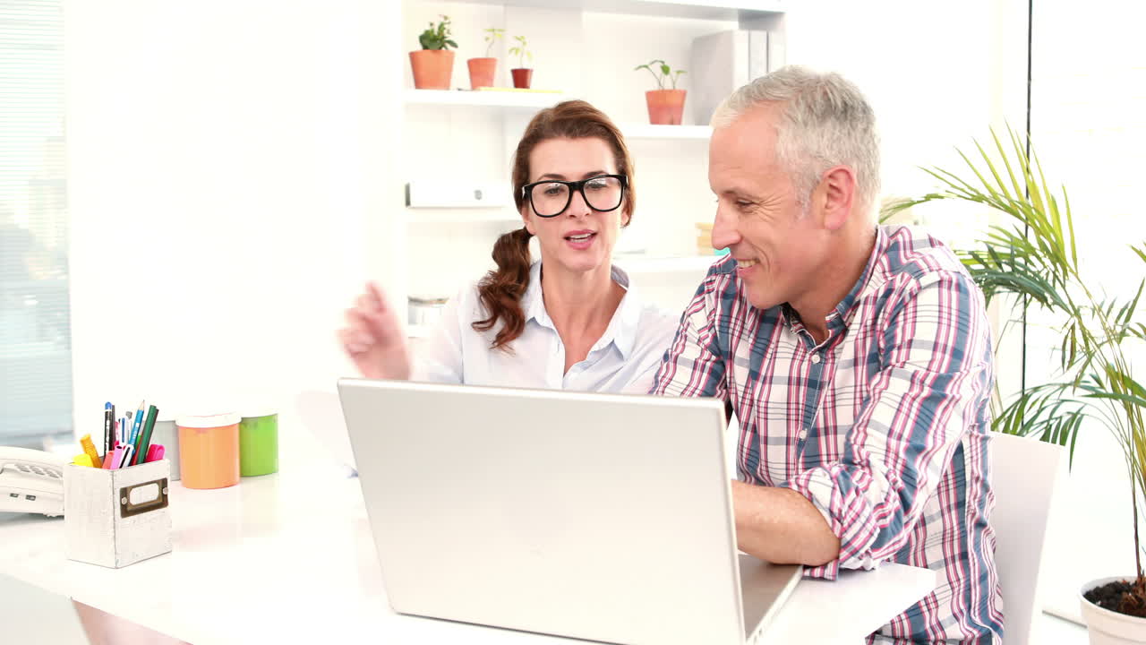 Trabajadores de oficina informales usando computadora portátil