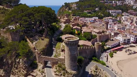 flying to the left above a castle on the edge of the sea in italy