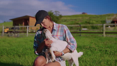 woman holding a baby goat on a farm