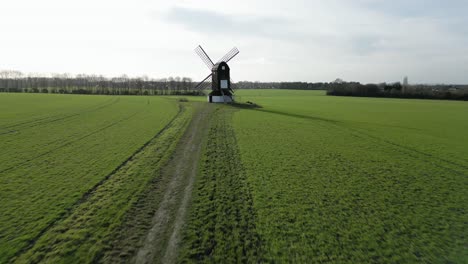 scenic windmill in rural countryside field, aerial drone flyaway