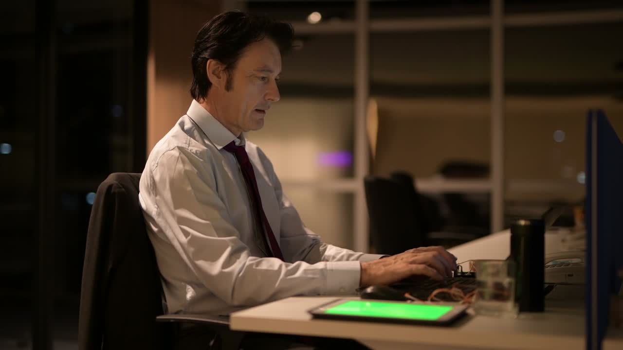 Mature Businessman Sitting And Working In Office At Night