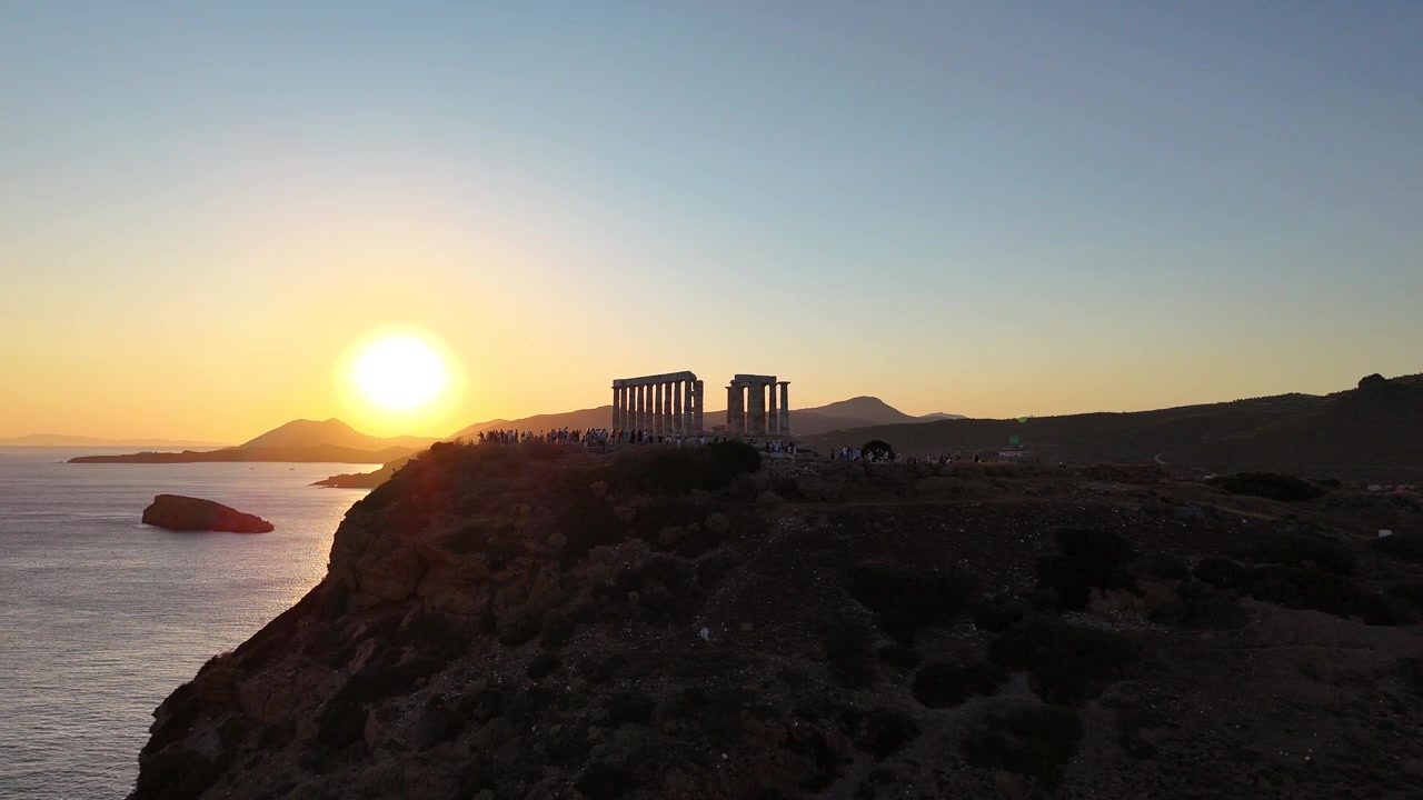 Imagens de drone 4K do icônico e antigo Templo de Poseidon, dramaticamente empoleirado nos penhascos do Cabo Sunião, com vista para as águas azuis cintilantes do Mar Mediterrâneo, perto de Atenas