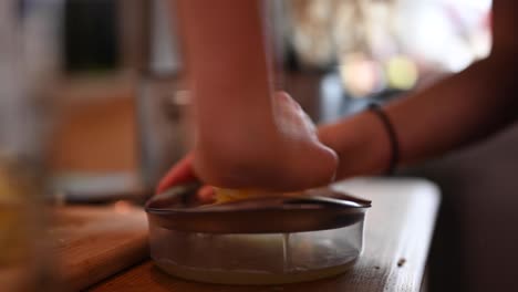 A-stationary-footage-of-a-woman's-hands-while-extracting-the-lemon's-juice-using-a-juicer