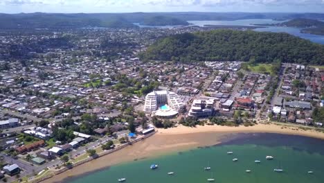 pull away shot of coastal suburb in sydney with white sand blue water tropical beach with waterfront houses. ettalong, australia.