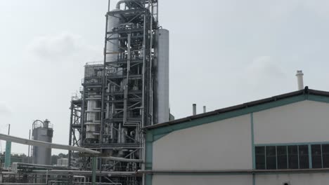 tall industrial processing unit behind factory building, overcast sky, veille-saint-girons, france