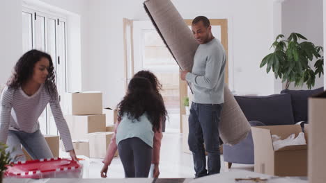 smiling family carrying boxes into new home on moving day