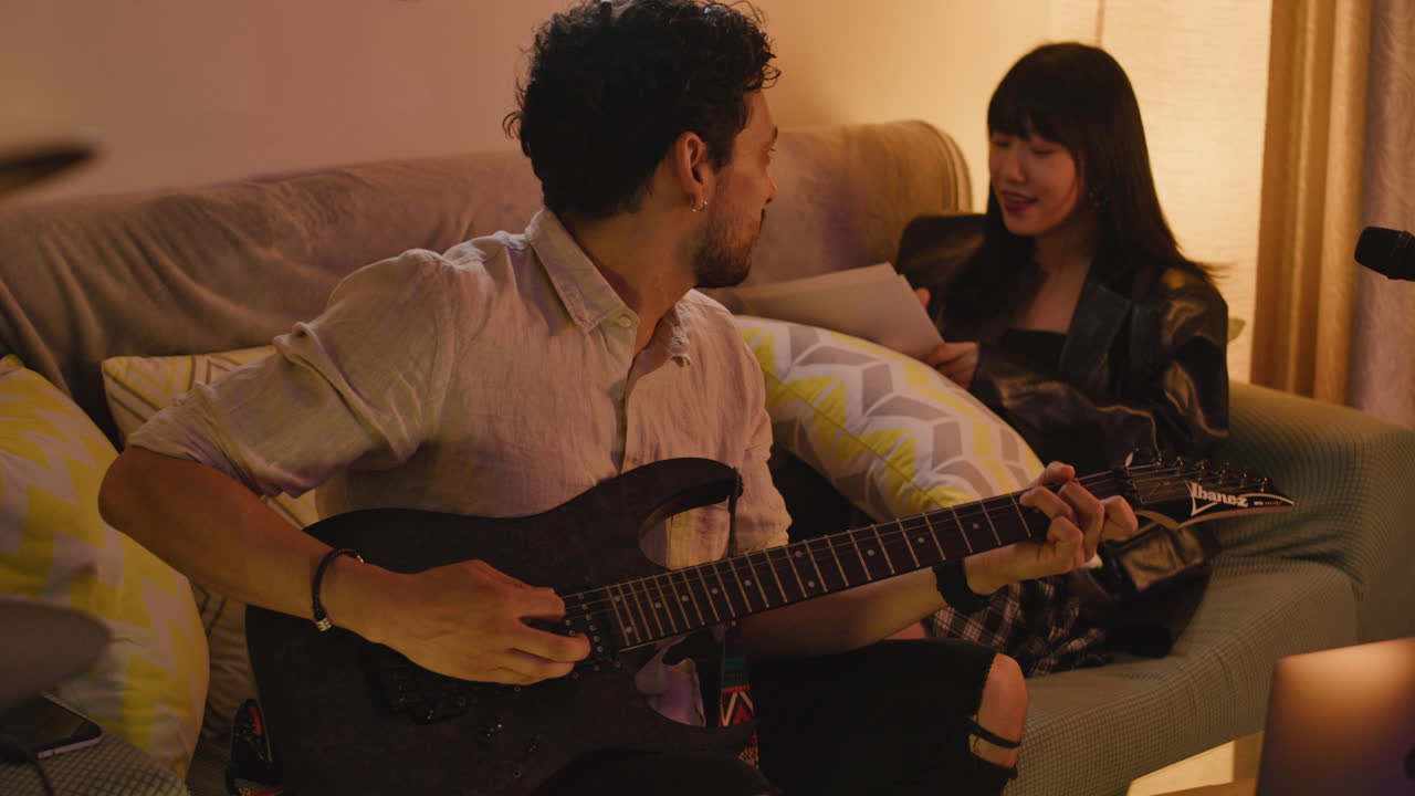 Couple playing music together at home