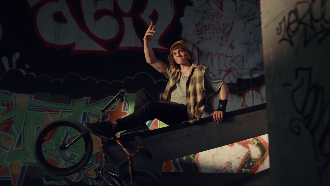 hombre elegante teniendo un descanso después del entrenamiento en el parque de skate.