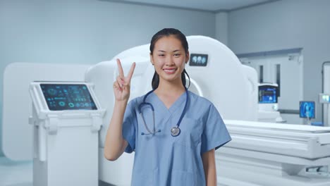 asian female doctor showing gesture peace and smiling with mri machine