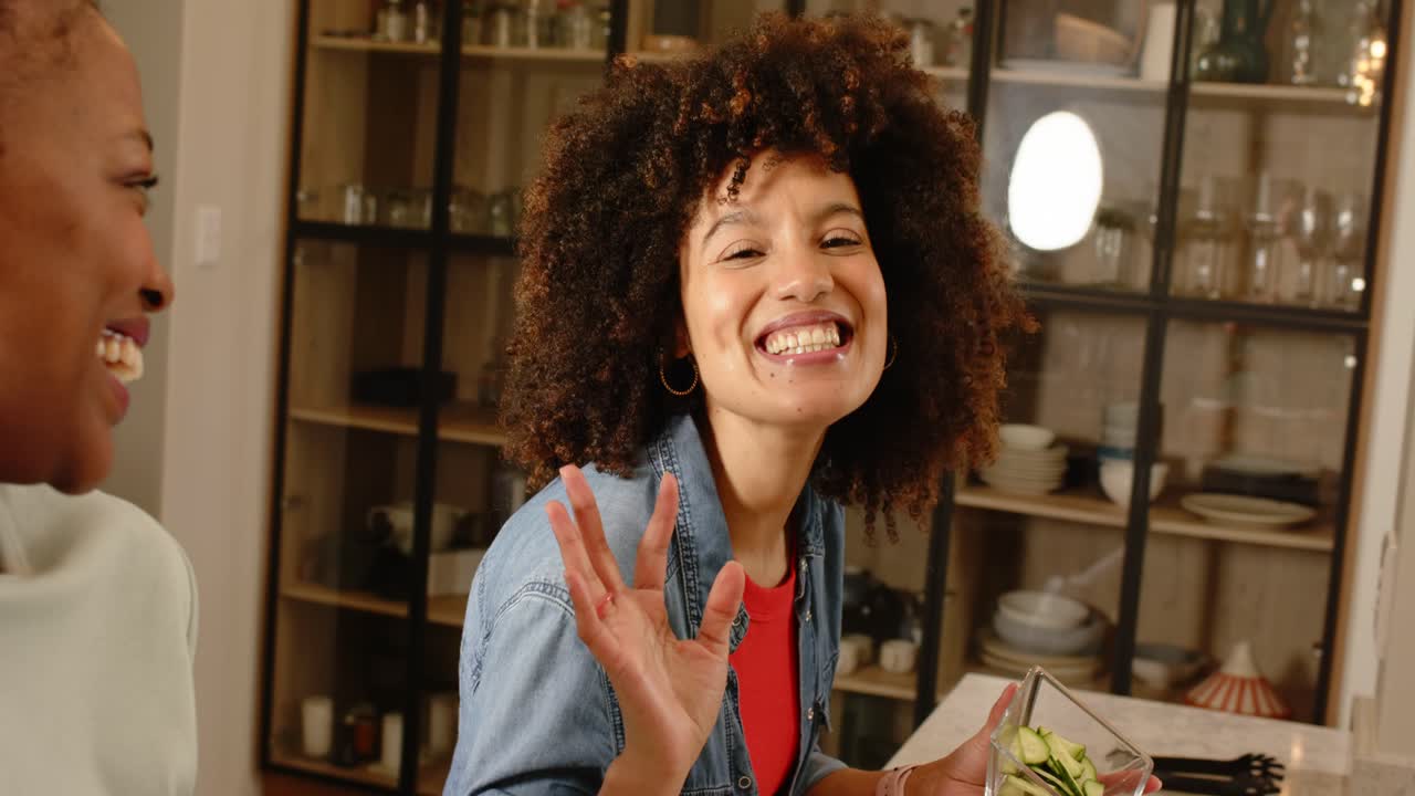 Saudando os espectadores, diversas amigas acenando e filmando receita de salada em ilha de cozinha