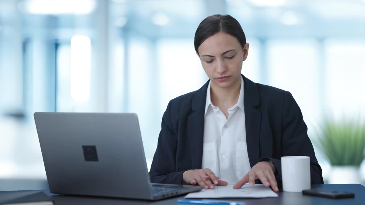 Seriøs indisk kvinnelig leder jobber på laptop