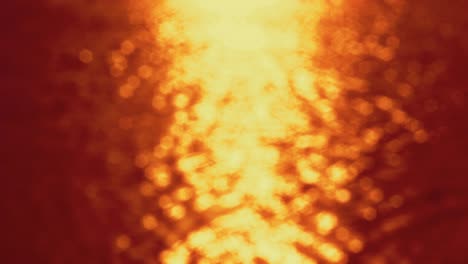 al atardecer - bucle sin costuras de una toma de 4k completamente desfocada de una hermosa superficie de agua ondulada y brillante en colores vívidos de fuego