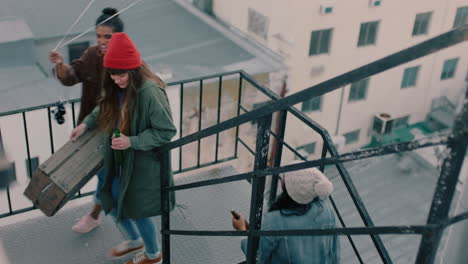 group-of-young-multiracial-friends-walking-up-fire-escape-stairs-to-rooftop-party-chatting-sharing-excitement-for-weekend-celebration