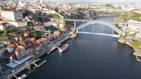 Drone-shot-flying-towards-bridge-in-Porto-Portugal-at-sunset