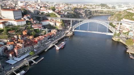 drone shot flying towards bridge in porto portugal at sunset