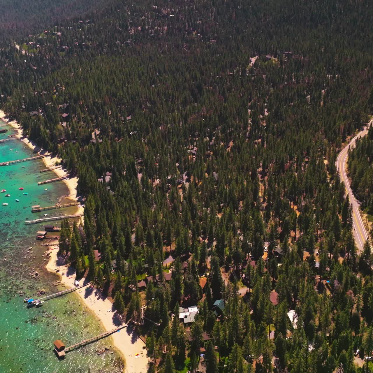 Cenário adorável do lago Tahoe com água azul e margem arborizada de pinheiros. Filmagem ensolarada da natureza exuberante vista do alto