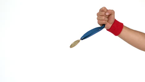 la mano que sostiene la medalla