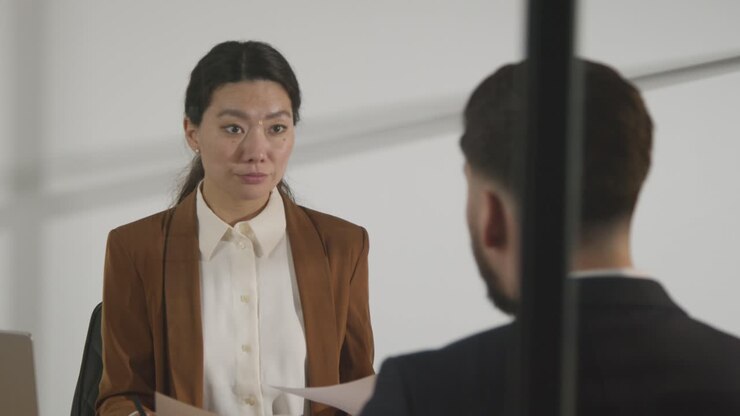 Male Candidate Being Interviewed In Office For Job By Female Interviewer Viewed Through Window 2