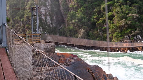pov walking over storms river mouth suspension footbridge in garden route