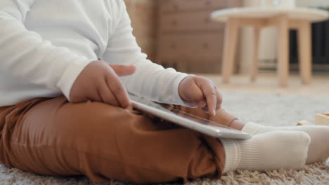 close up of baby boy playing with tablet
