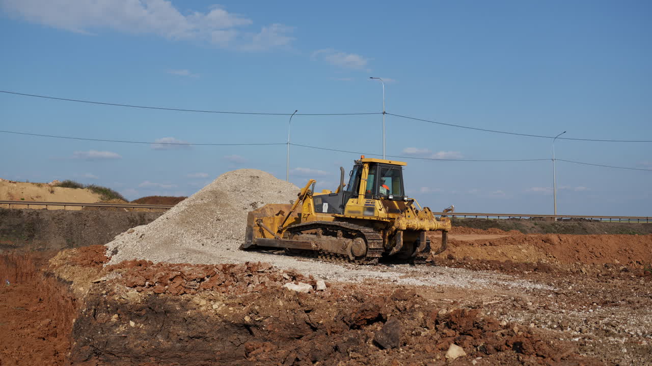 Yellow Bulldozer at a Construction Site with a Pile of Gravel
