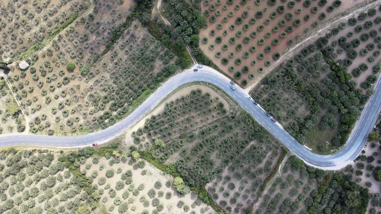 A static, bird's-eye view of a highway cutting through a patchwork of fields in Les Beaux de Provence, France