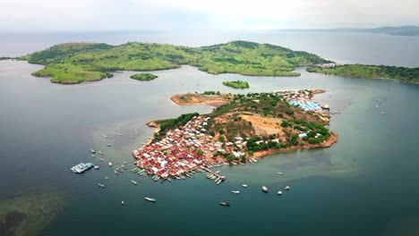 Drone-shot-of-small-fishermen-village-at-the-isolated-island-Bajo-Pulau-in-the-Indian-Ocean,-near-Sumbawa-Island,-Indonesia-filmed-at-sunset