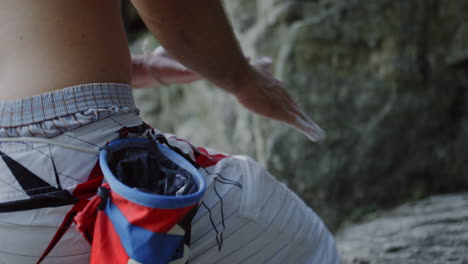 escalada en primer plano polvo de tiza manos sacudidas, polvo de escalada en roca, rocas, frotamiento polvo de magnesio talco más agarre para la escalada en la montaña, deportes hombre atlético, al aire libre solo escalada libre, soleado