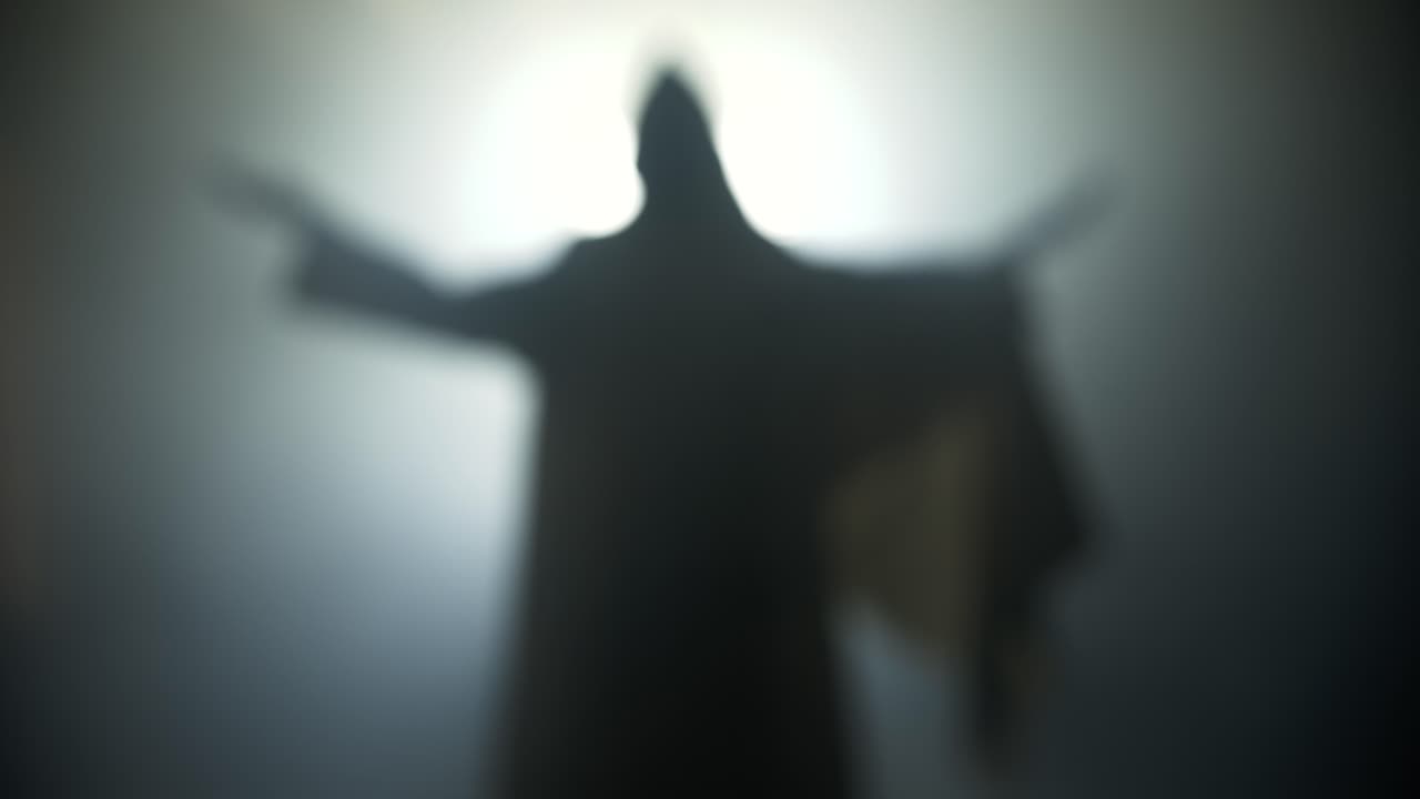 Silhouette of resurrection of Jesus Christ inside the tomb, in bright light, raising his hands in dramatic, cinematic slow motion. Perfect for Easter resurrection visual.