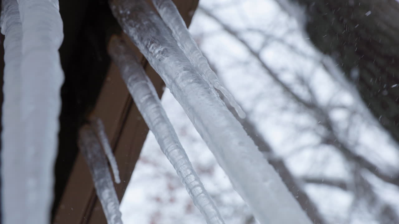 scatto a mano di grandi ghiaccioli appesi da un balcone