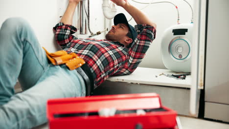 plumber repairing plumbing under a sink