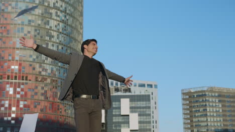 joyful businessman throwing documents on street