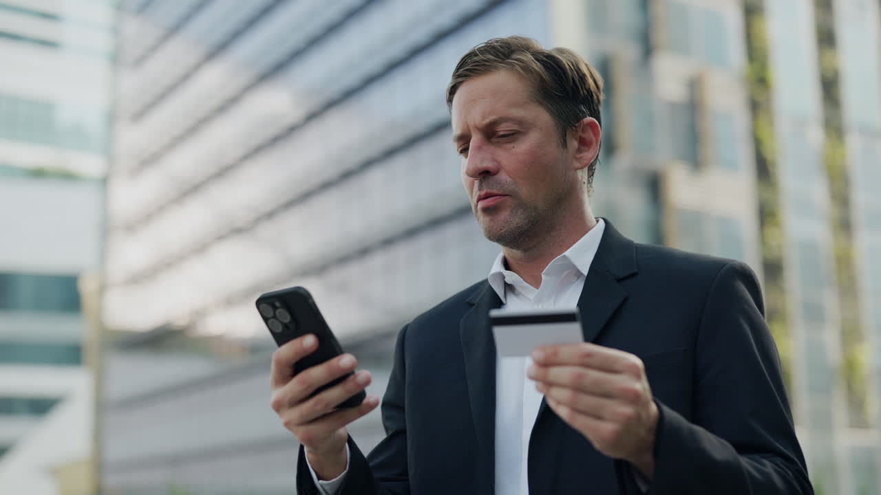 Businessman using phone and credit card