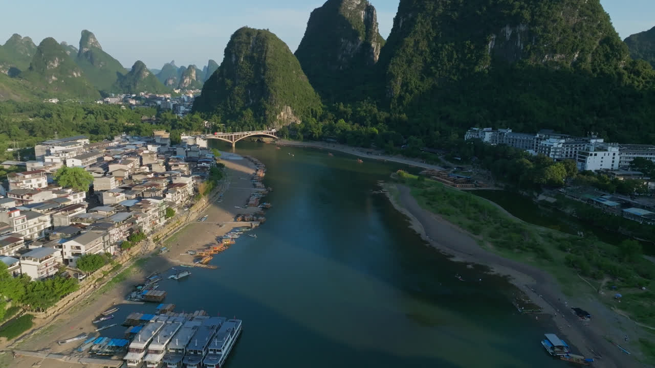 Drone tilting along the Li river, toward mountains, sunset in Yangshuo, China