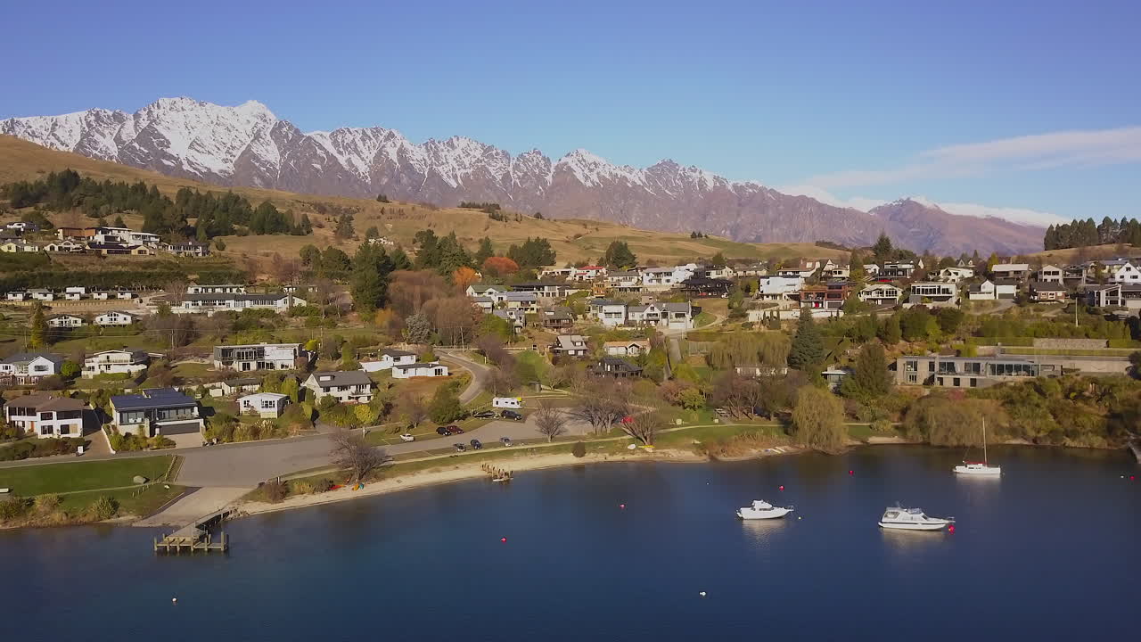 yates amarrados en la bahía de queenstown con en el fondo la alta cordillera notables
