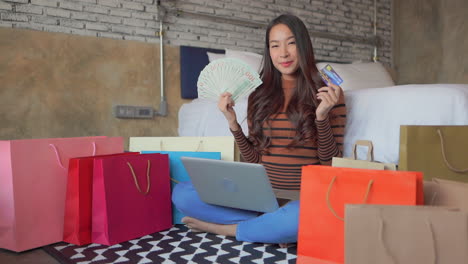 mujer feliz comprando con efectivo y tarjeta de crédito
