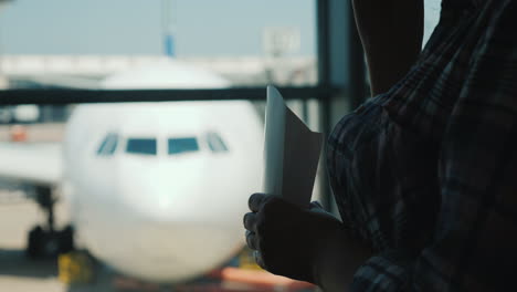 Silhouette-Einer-Frau-Am-Fenster-Eines-Flughafenterminals,-Die-Snacks-Isst,-Während-Sie-Auf-Einen-Flug-Wartet