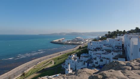 Mit-Blick-Auf-Weiße-Häuser-Am-Hang-Mit-Blick-Nach-Links-Auf-Die-Route-De-La-Plage-In-Merkala-Neben-Der-Straße-Von-Gibraltar,-Tanger