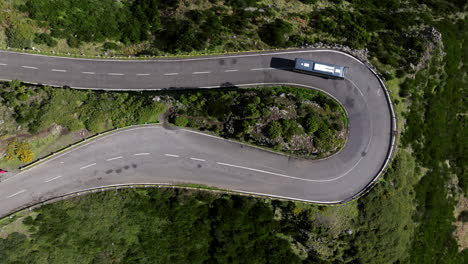 Vista-Aérea-Del-Autobús-Que-Conduce-A-Través-De-Una-Carretera-Cerrada-Cuesta-Arriba-En-La-Montaña-En-La-Isla-De-Madeira,-Portugal