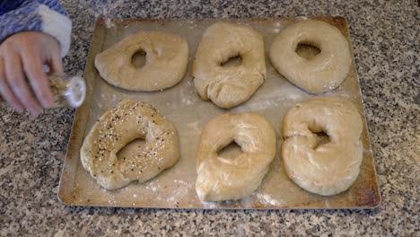 Verteilen-Sie-Alle-Gewürze-Auf-Hausgemachten-Sauerteig-Bagels,-Bevor-Sie-Sie-Zum-Backen-In-Den-Ofen-Schieben